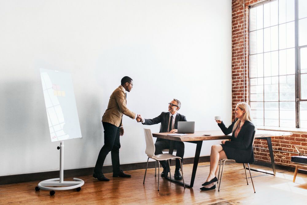 businessmen-handshake-after-a-presentation (1) profissional sendo comprimentado após apresentação, simbolizando a valorização do capital humano por parte das empresas